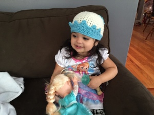 Doodlebug in her Elsa nightgown, with her Elsa knit cap and her Elsa doll, probably watching ... well, Elsa.